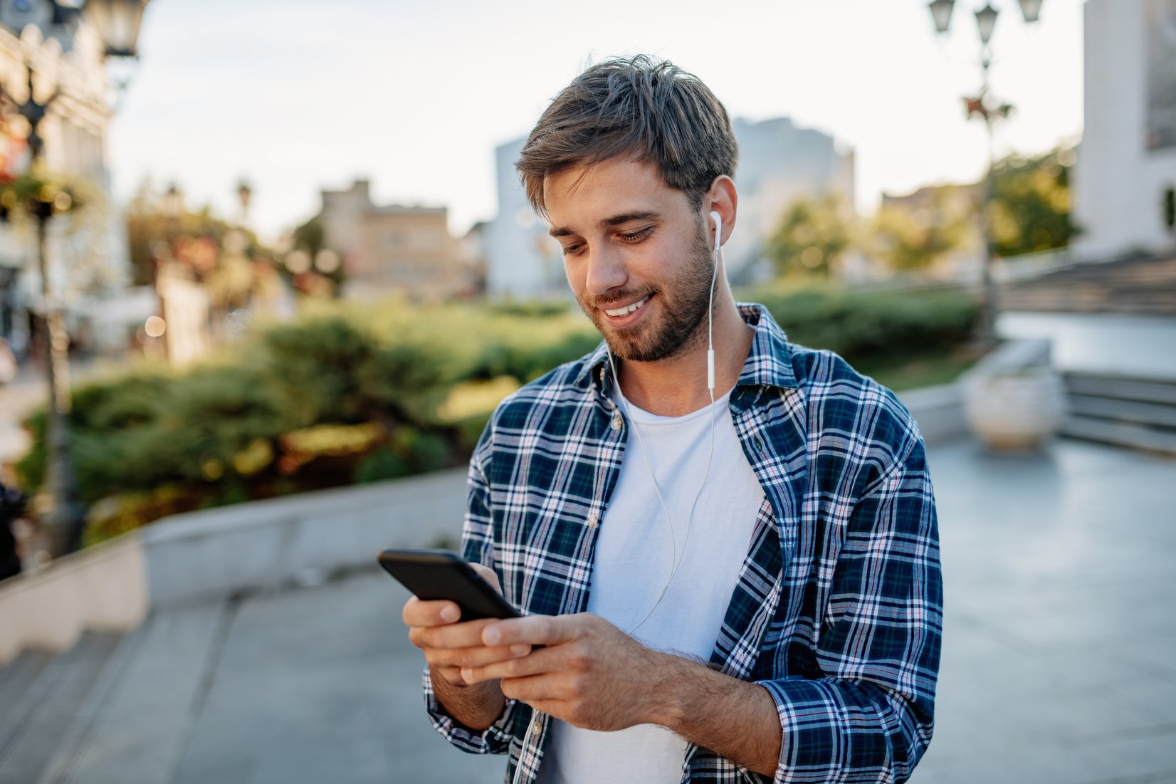 Handsome millennial guy using mobile phone